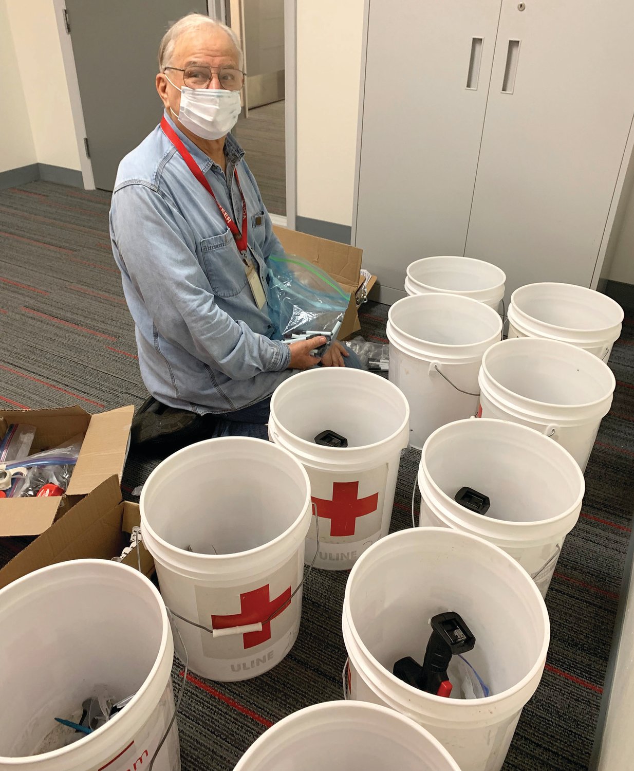 Red Cross volunteer Jerry Jensen preparing supplies for smoke alarm installations.